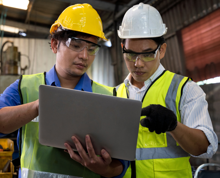 Two Workers In Manufacturing Plant On Laptop